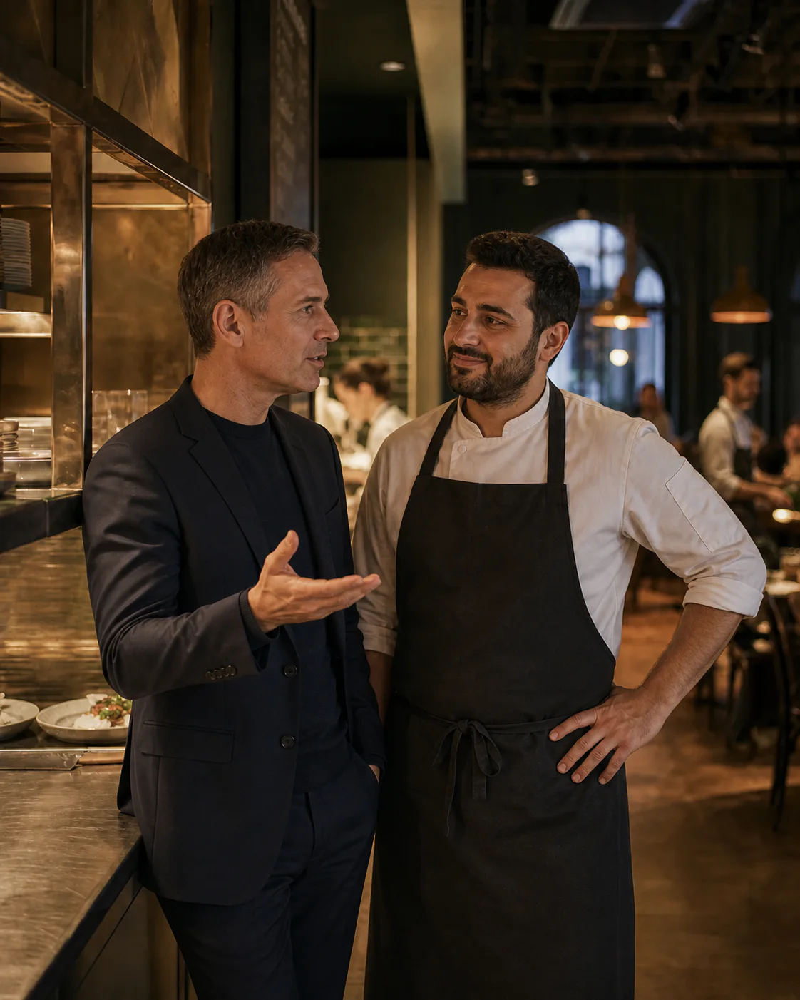 Gastro-Berater und Restaurantinhaber besprechen digitale Lösungen in einer Restaurantküche